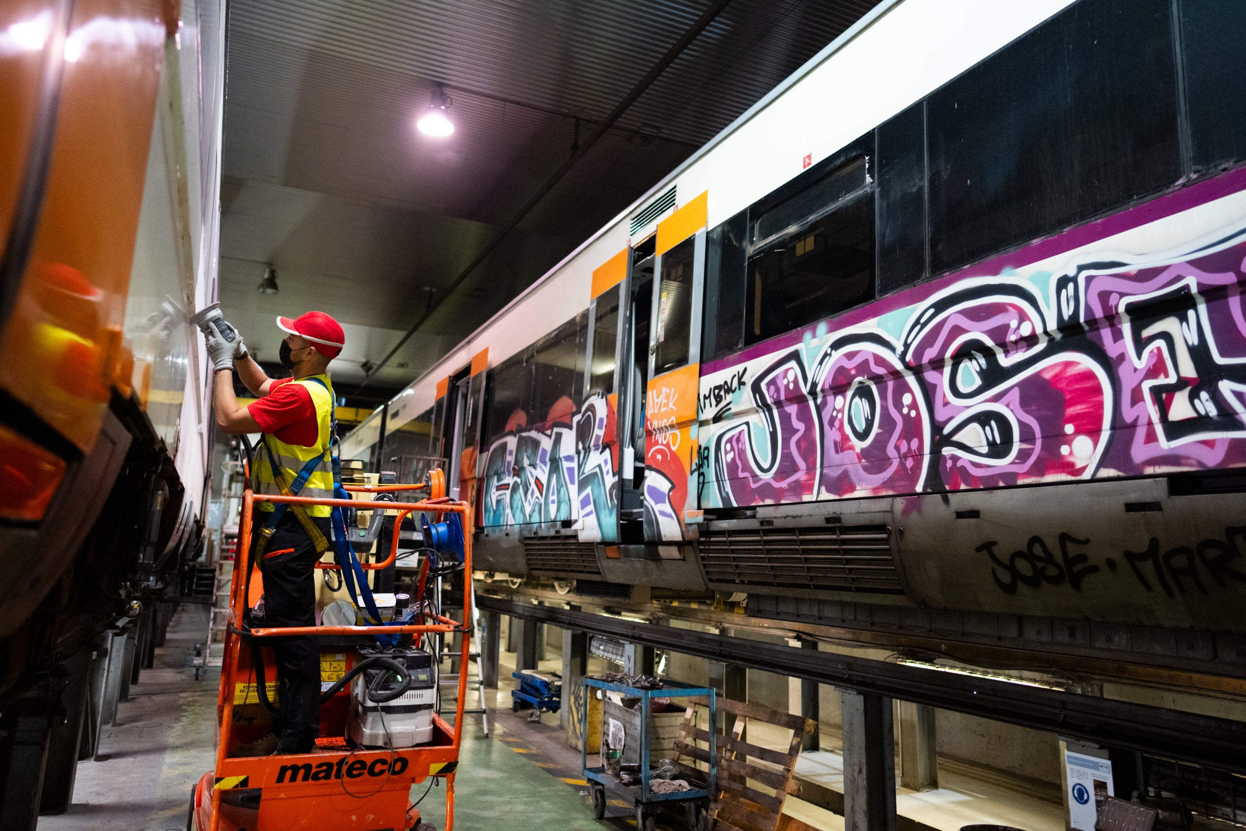 Un operari de Renfe neteja grafitis en un tren a la base de manteniment de Cornellà / ACN