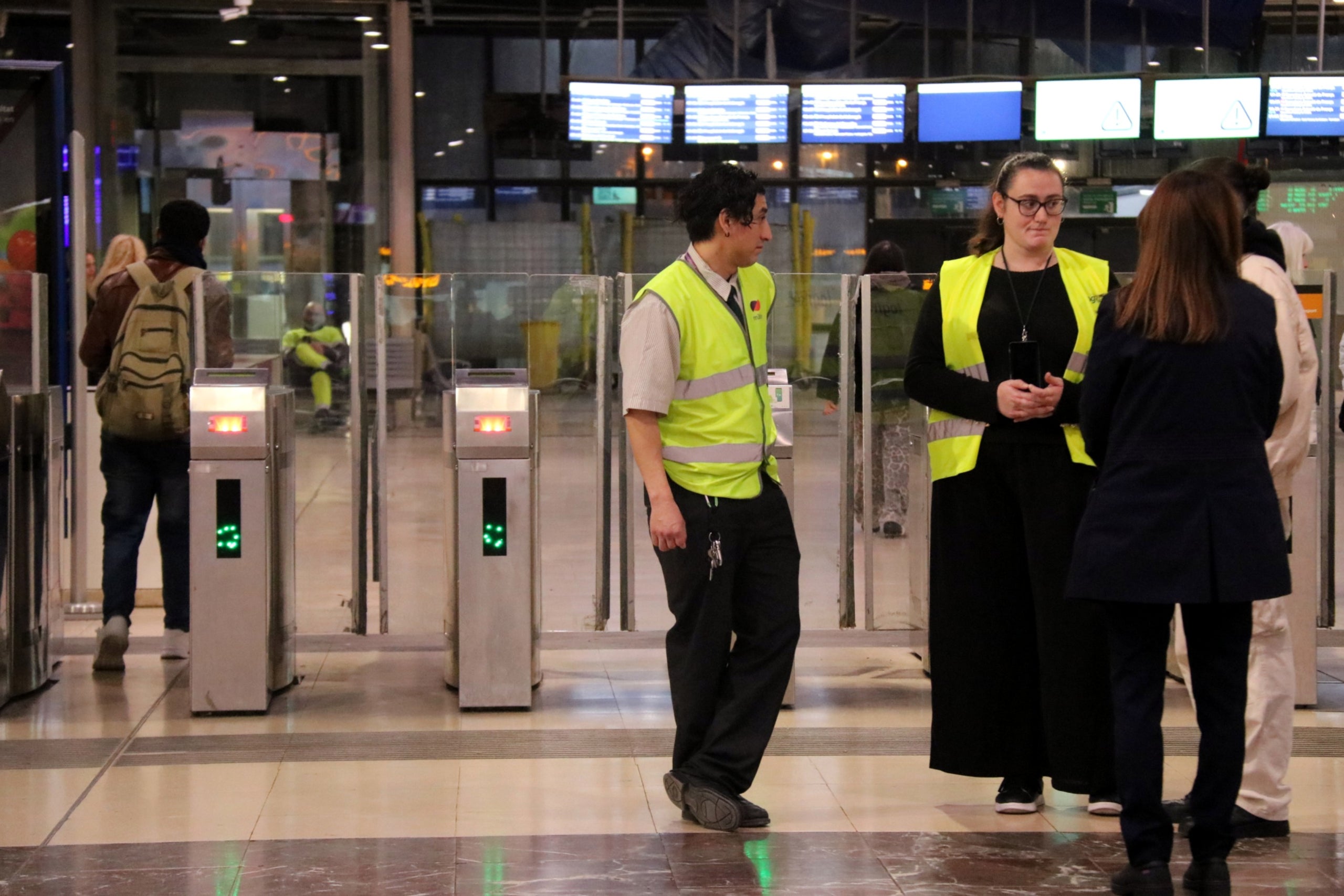 Dos informadors de Renfe parlen amb usuaris a l'estació de Sants / ACN
