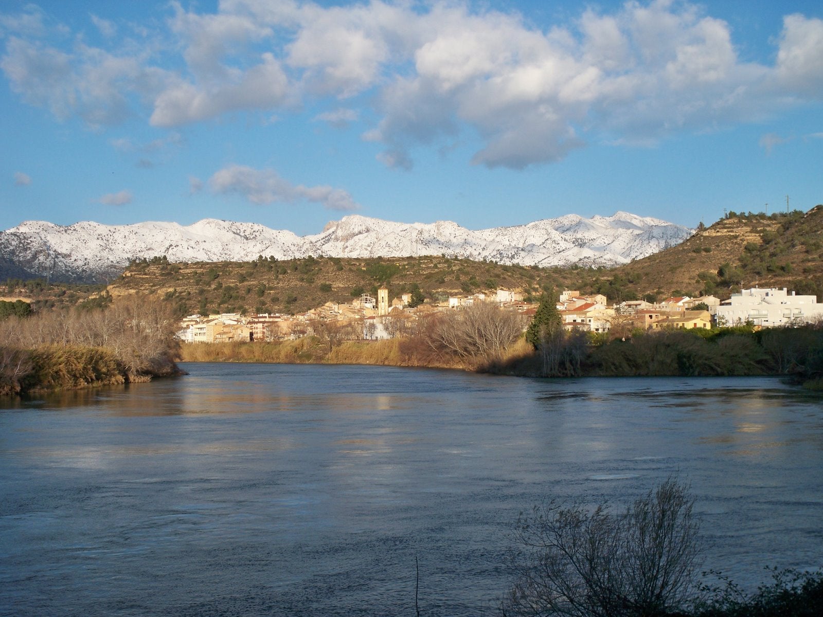 Imatge del poble de Tivenys amb la serra de Cardó de fons emblanquinada / Credit Commons