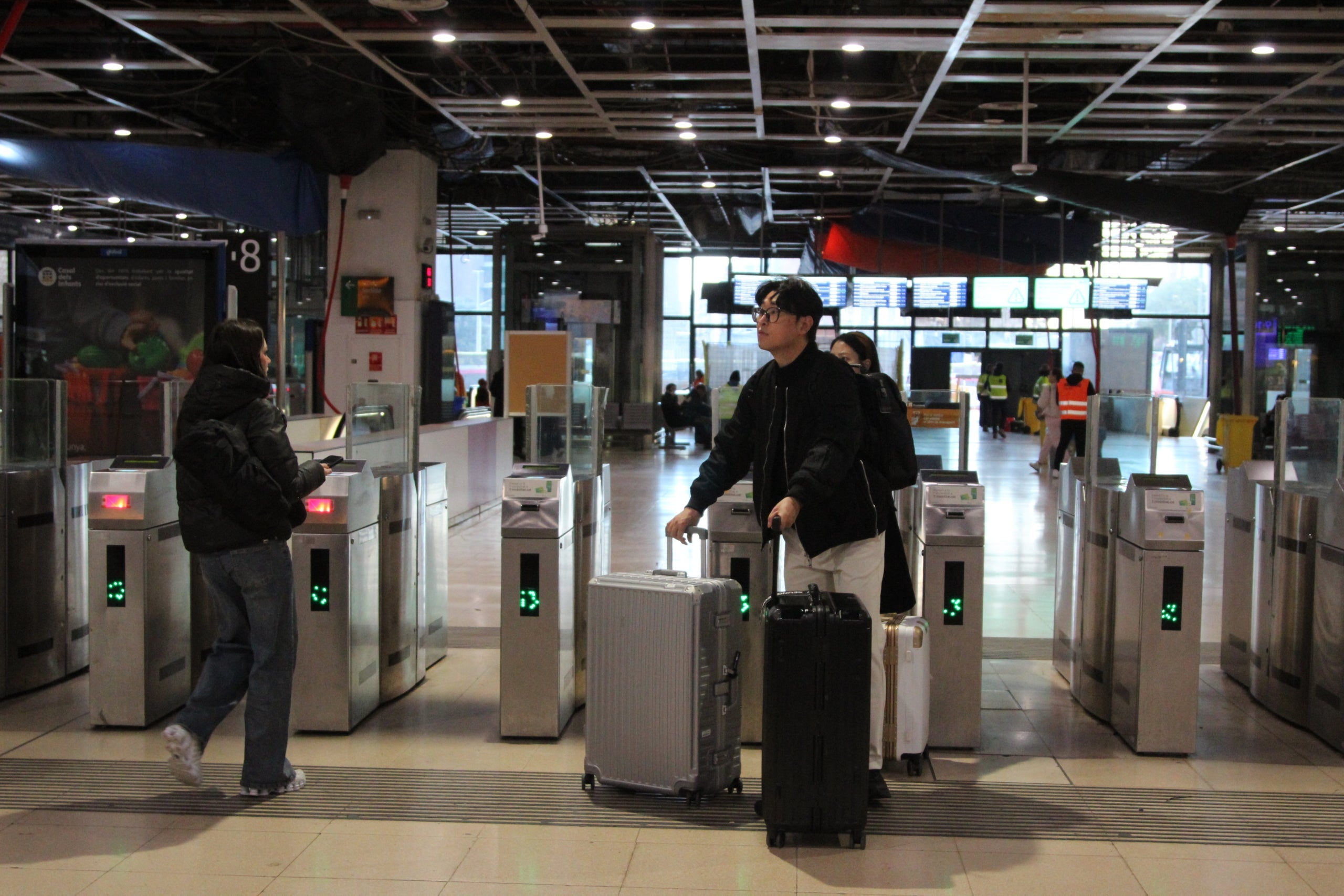 Passatgers desconcertats el dia del suposat restabliment progressiu del servei de Rodalies, aquest dilluns al matí a l'estació de Sants / Anton Rosa