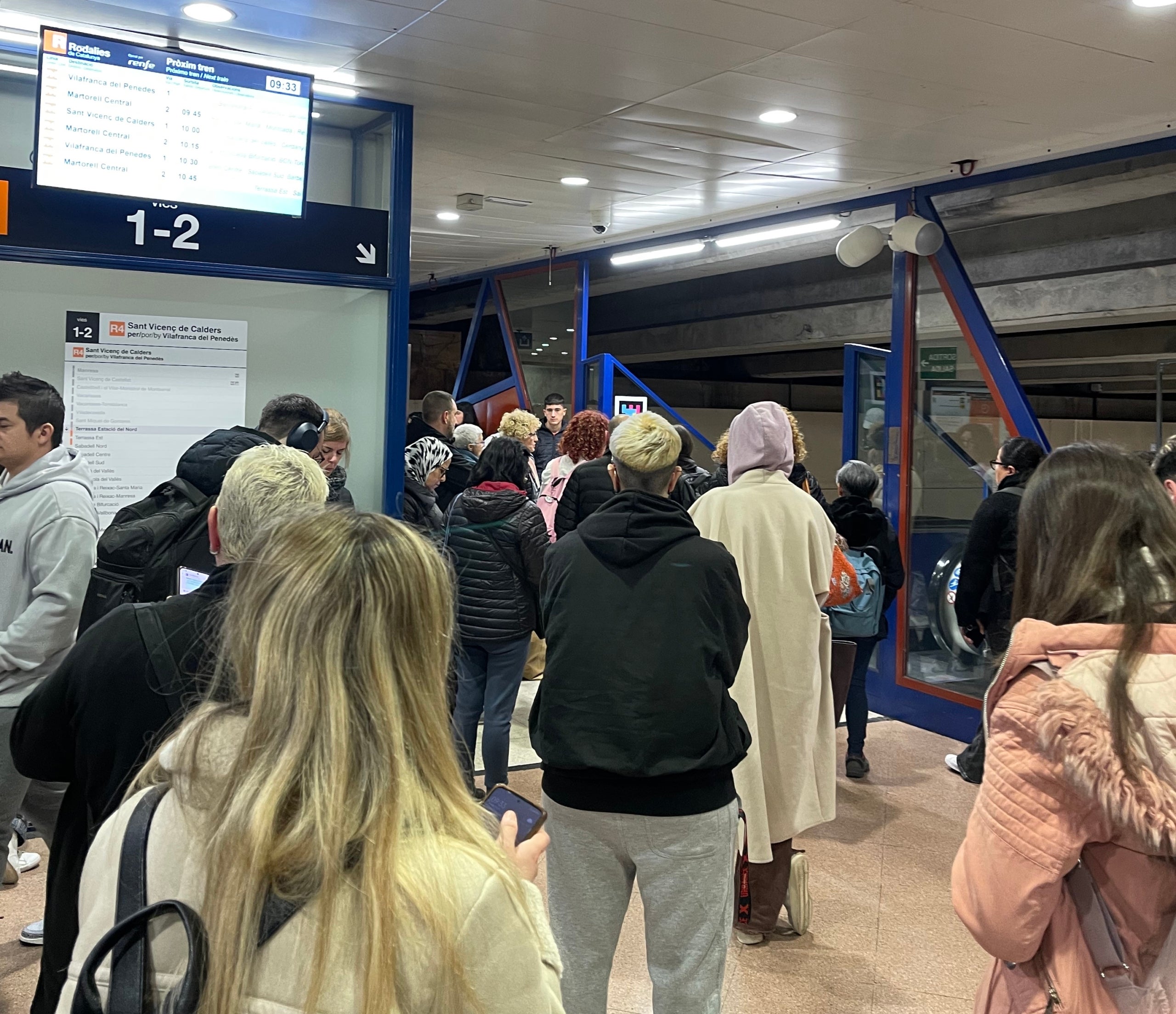 Viatgers que arriben del Bus esperant que a l'estació de Terrassa els deixin baixar a l'andana/QS