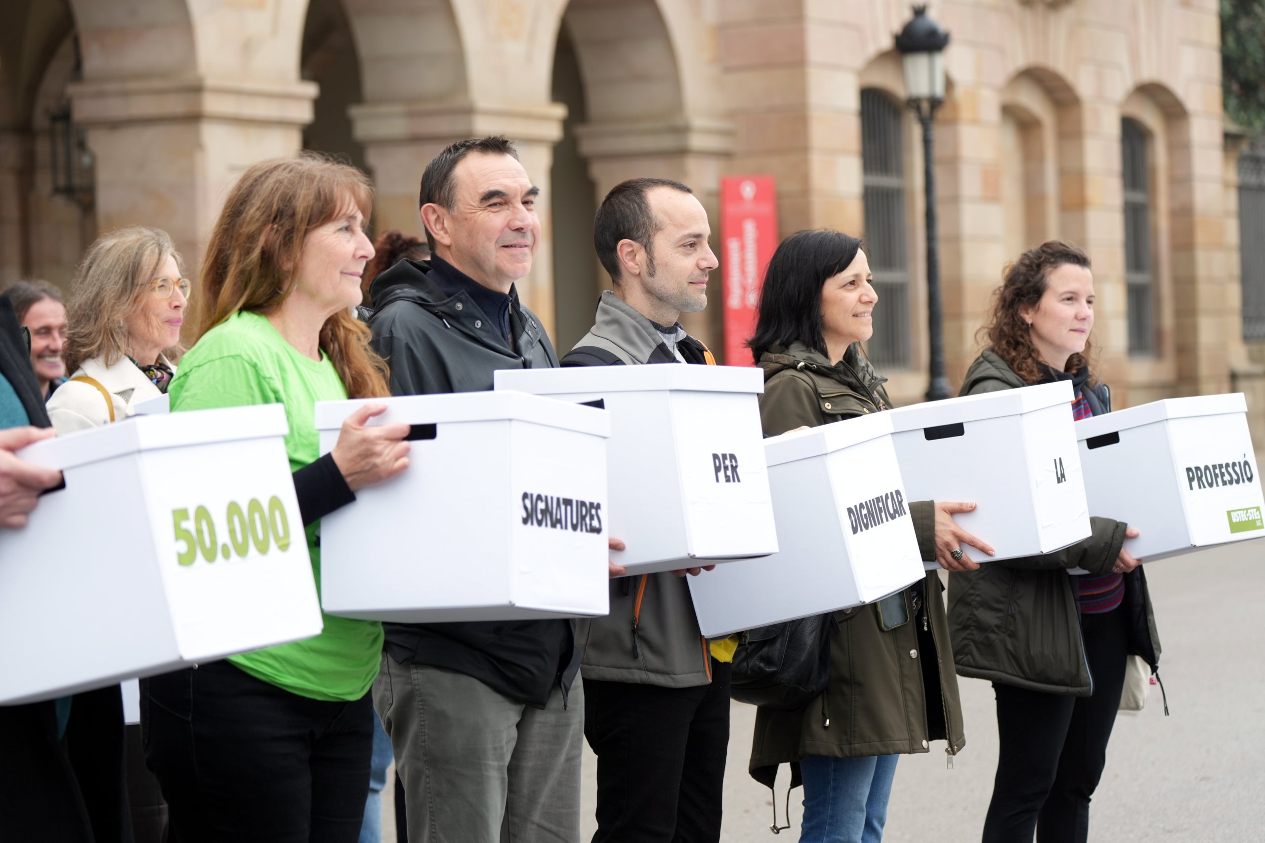 Els membres d'USTEC-STEs amb les caixes on duen les 50.000 signatures per reclamar millores a la professió docent  / ACN
