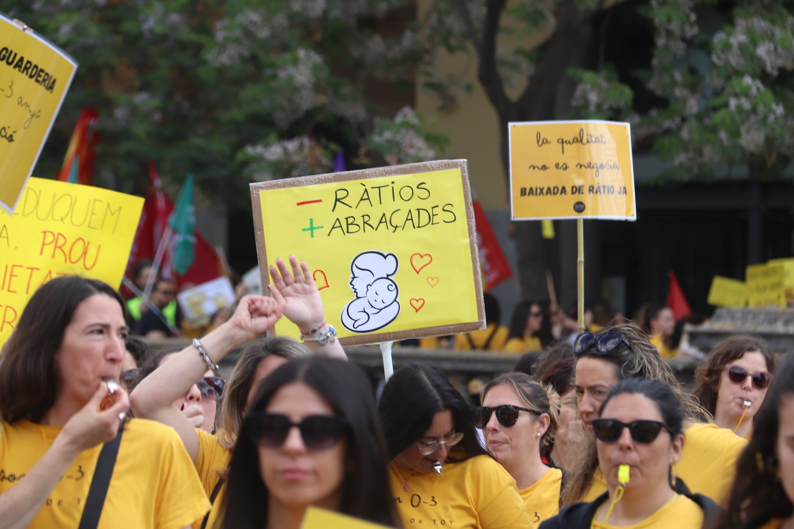 Una pancarta demana menys ràtios i més abraçades a les escoles bressol en una manifestació de Girona | Aleix Freixas (ACN)
