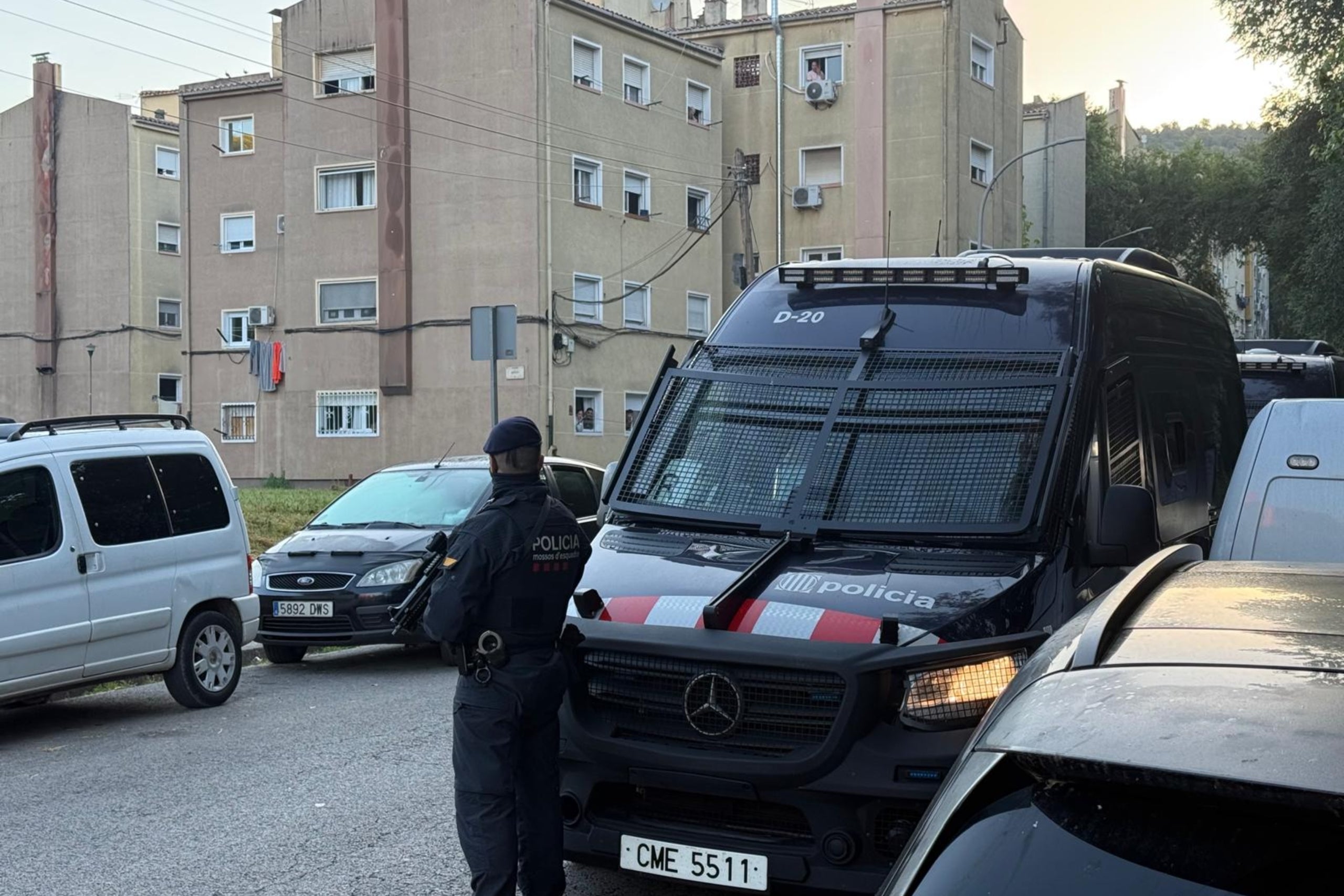 Un agente de los Mossos d'Esquadra vigila frente a una furgoneta en medio de un operativo en el barrio de Font de la Pólvora | Gerard Vilà (ACN)
