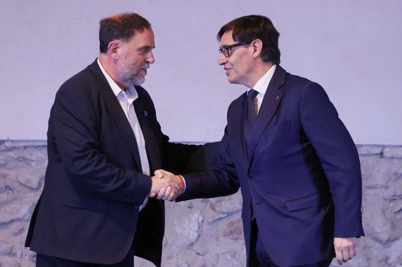 Apretón de manos entre el presidente de la Generalitat, Salvador Illa, y el presidente de ERC, Oriol Junqueras, durante el acto de impulso de la Línea Orbital Ferroviaria / Rubén Moreno