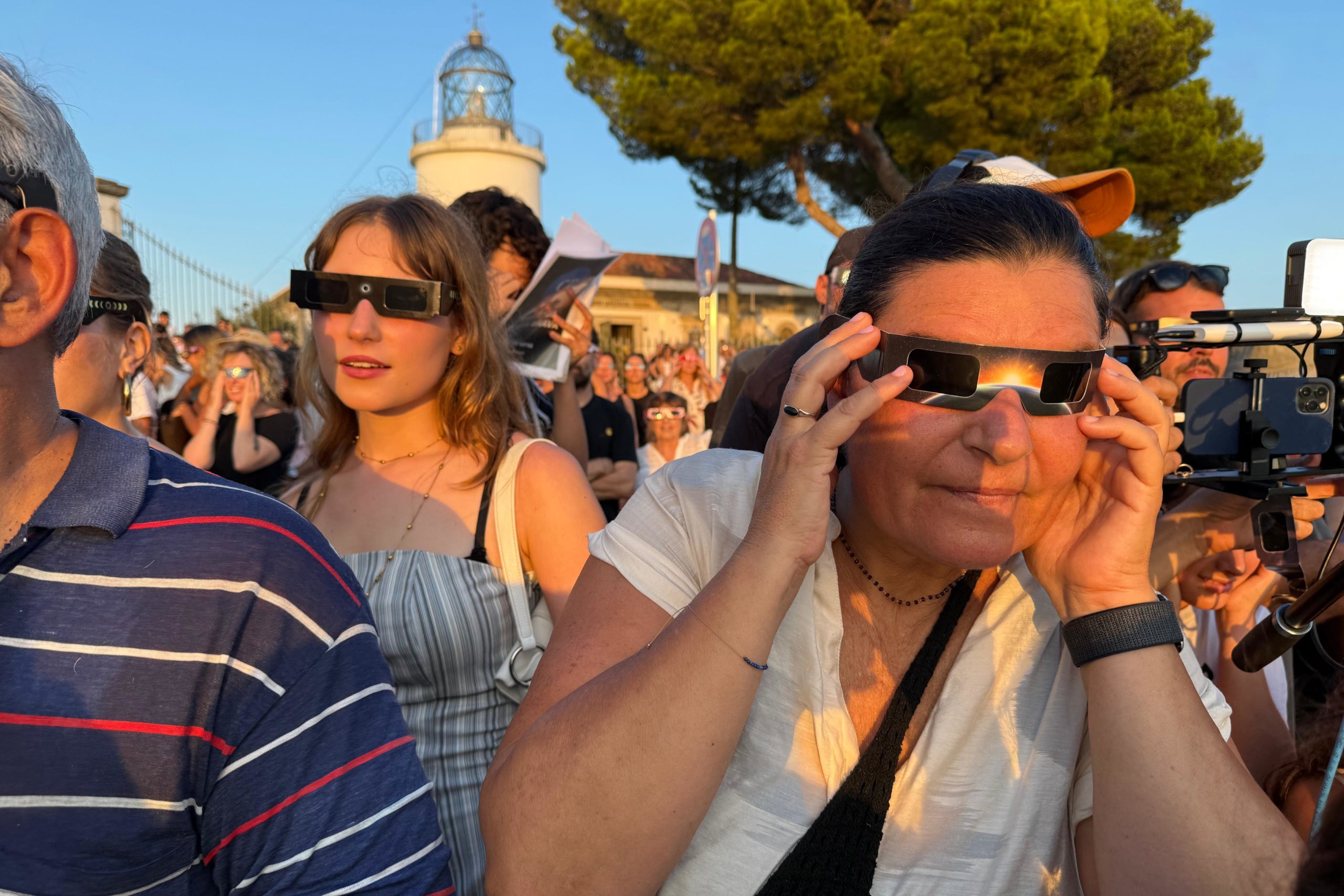 Una dona mira l'eclipsi dels del far de Sant Sebastià.

Autor: Gerard Vilà (ACN)