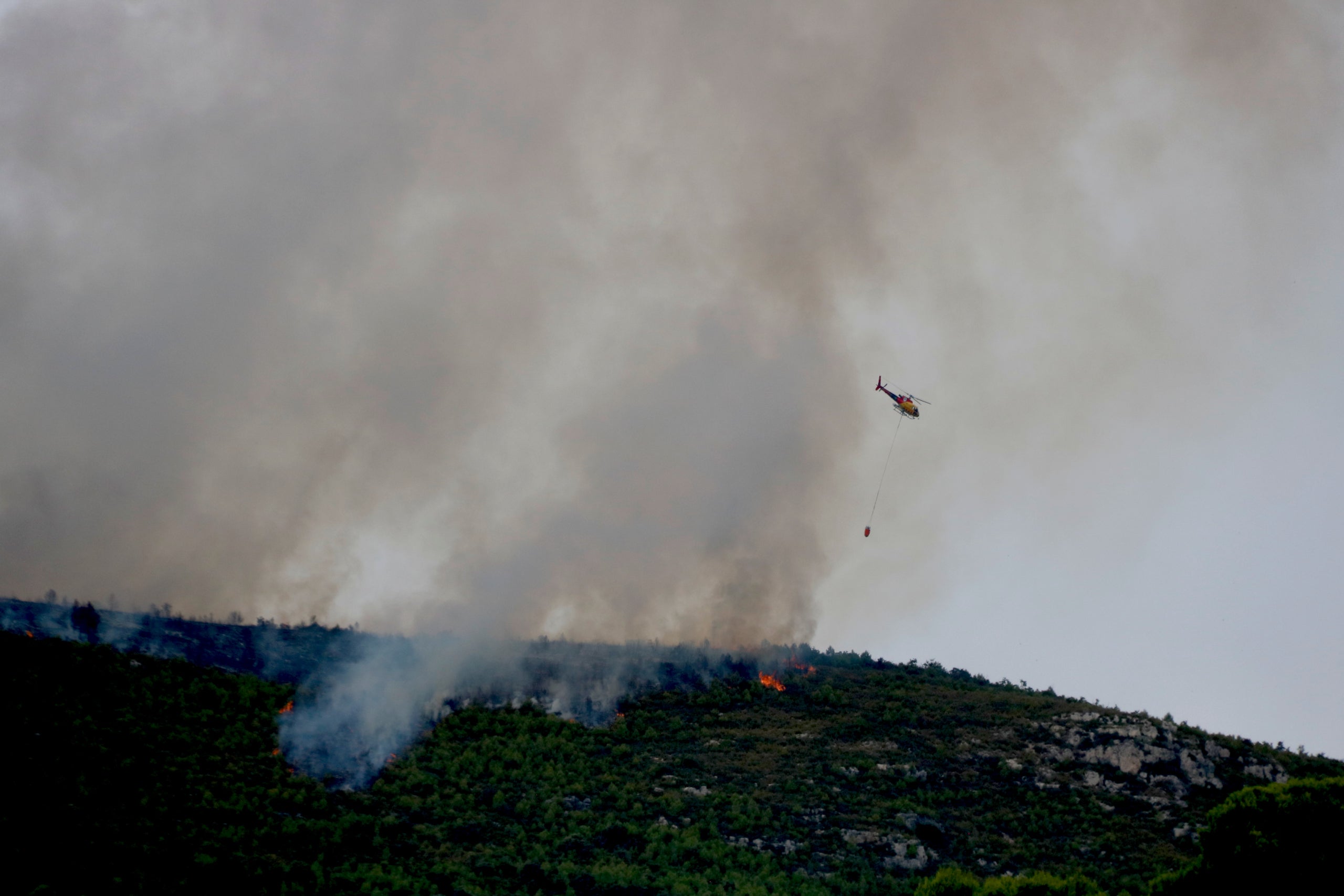 Un helic&ograve;pter treballa en les tasques d'extinci&oacute; de l'incendi de Querol | Arnau Mart&iacute;nez / Gio Gonzales (ACN)