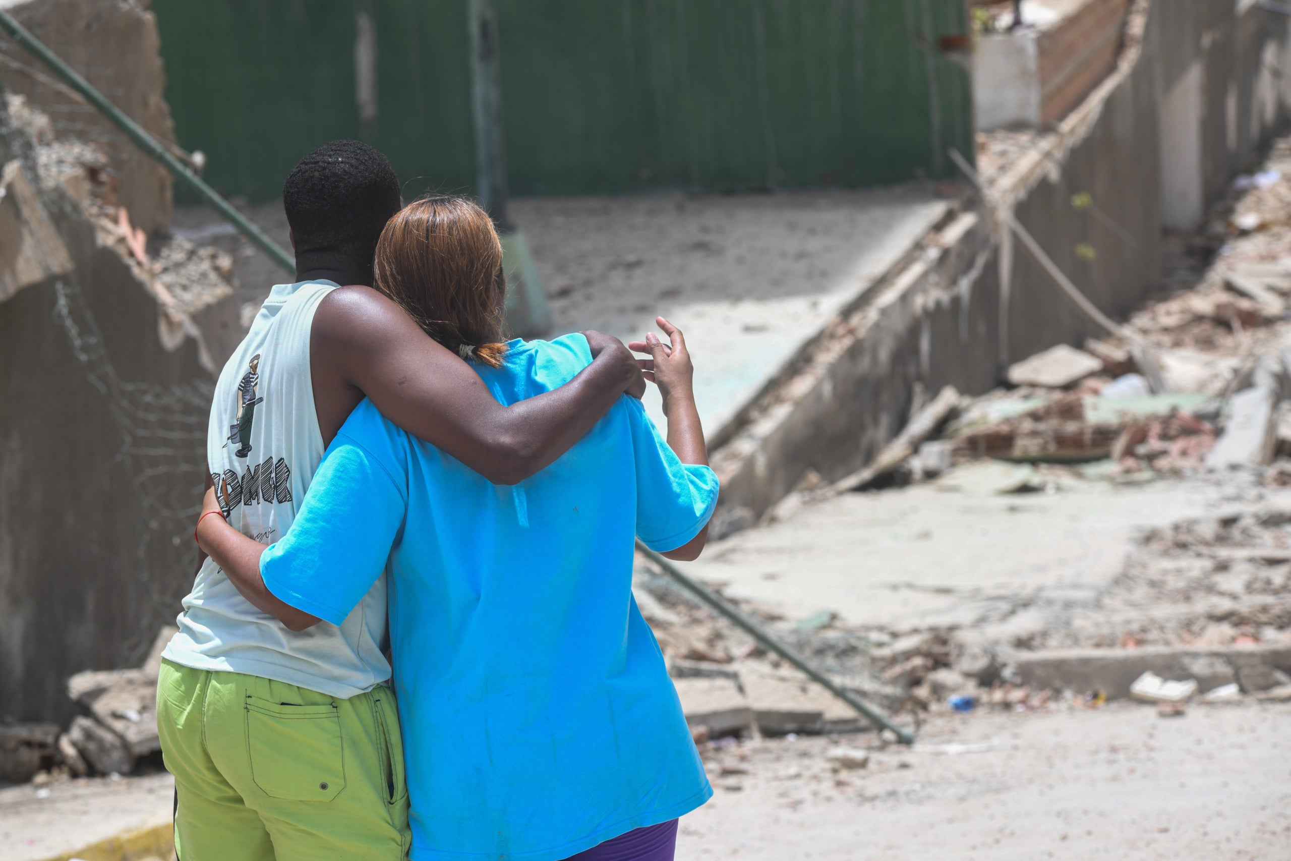 Una pareja abraza frente a un edificio colapsado en el estado de La Guaira. Europa Press/Contacto/Marcos Salgado