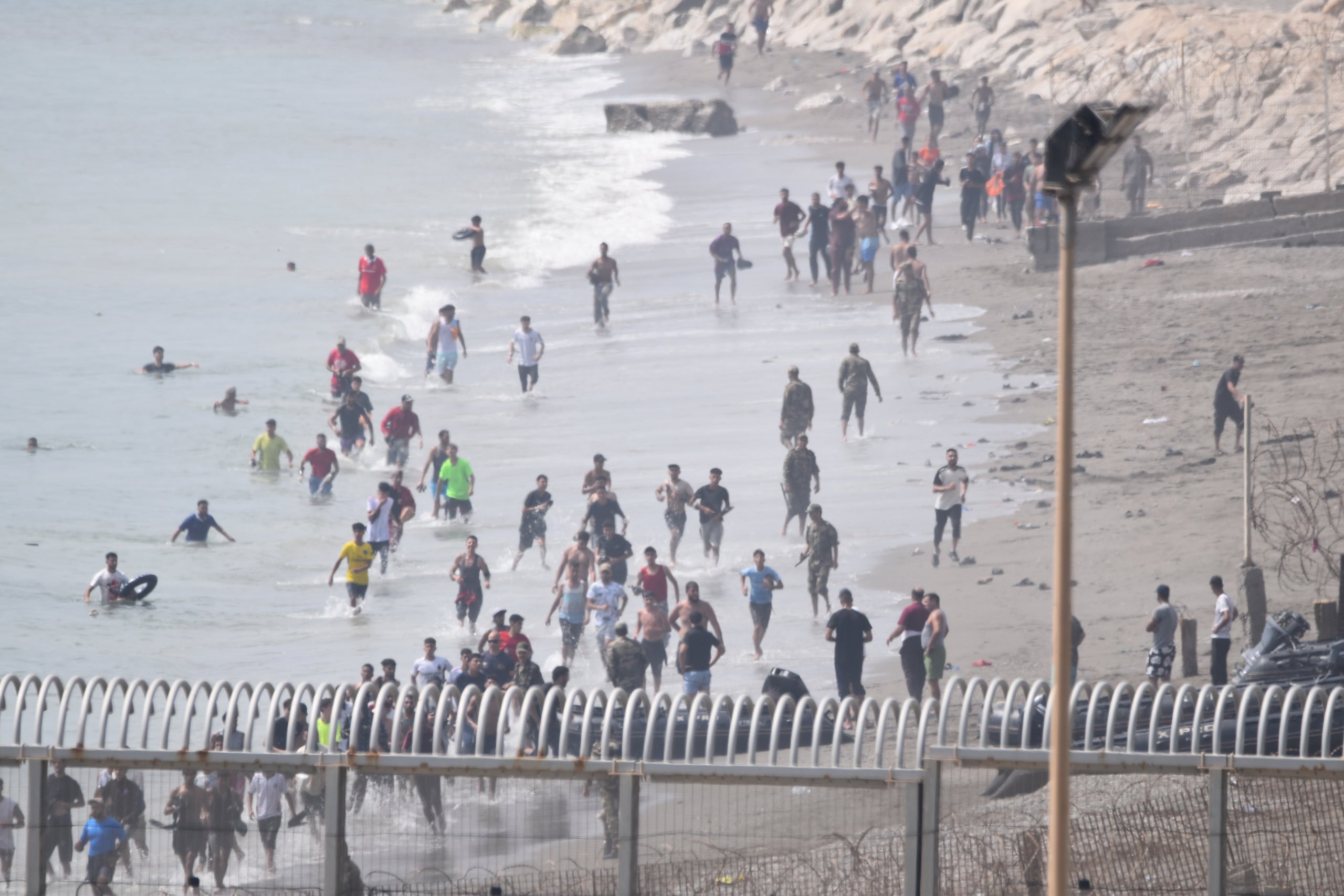 Desenes de migrants intenten passar la frontera de Ceuta nedant / EP
