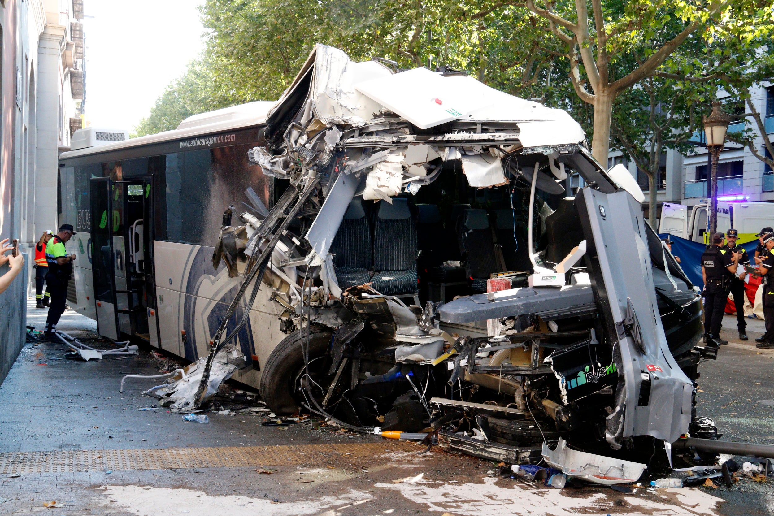Un mosso inspecciona l'autocar accidentat a la rambla de Ferran de Lleida, al davant del Palau de la Diputació. | Roger Segura (ACN)