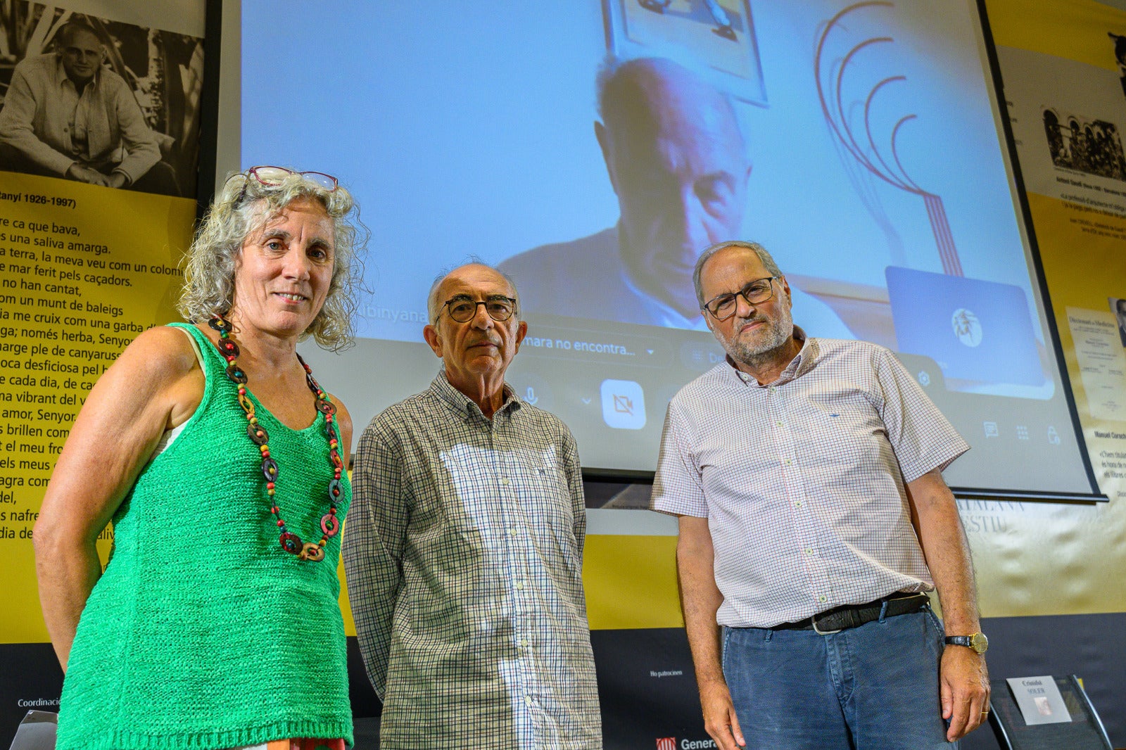 Quim Torra, Cristófol Soller, Marta Poblet i Albinyana, a la pantalla, a l'acte d'aquesta tarda a l'UCE/Josep Maria Muntaner/UCE