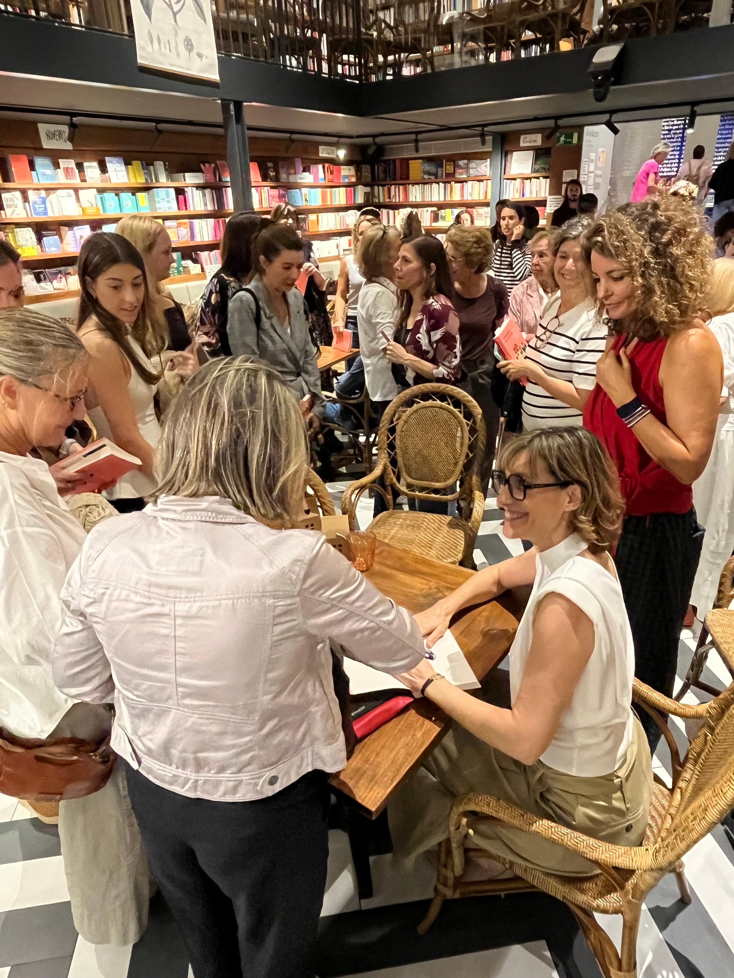 Esperança Sierra envoltada de fans i amigues, o amigues i fans, a punt de signar exemplars de 'Totes les cases felices' (La Campana), al final de la presentació de la llibreria Ona / S.B.
