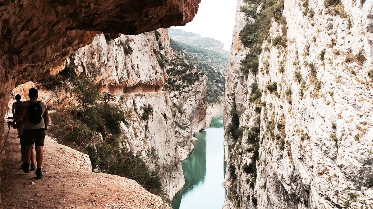 Excursionistes avançant pel camí estret del Congost