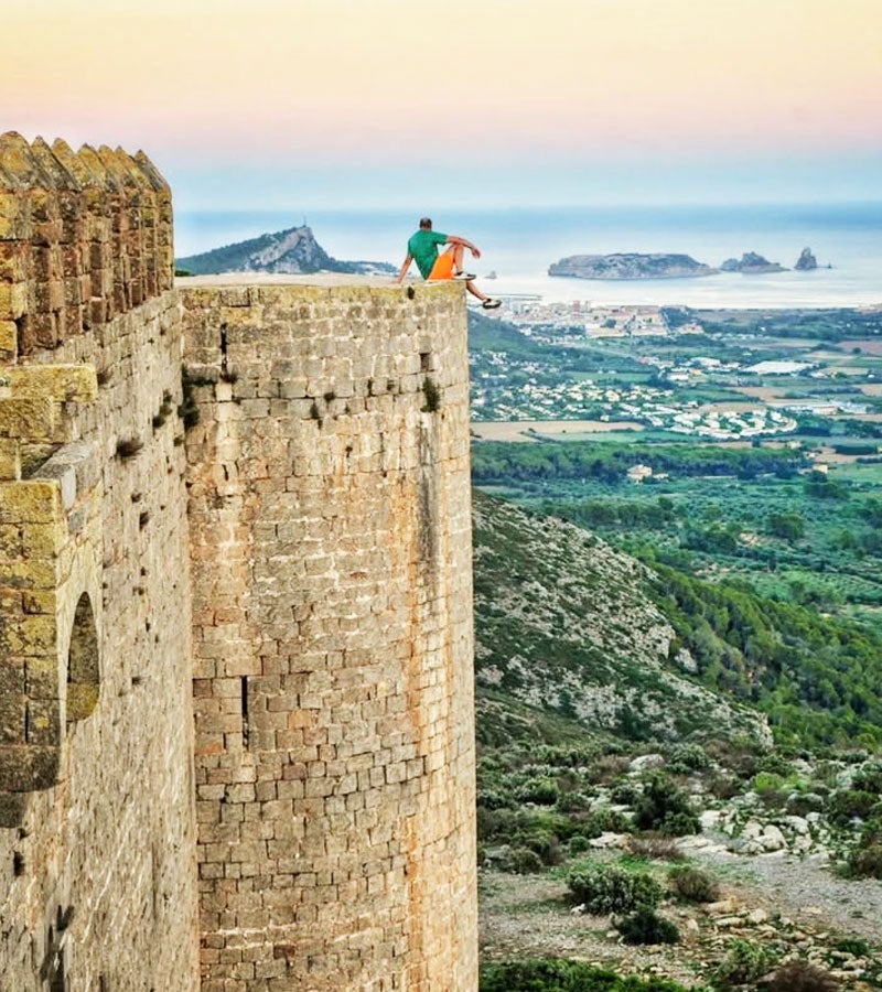 Un excursionista mirant les illes Medes des de la torra del castell de Montgri