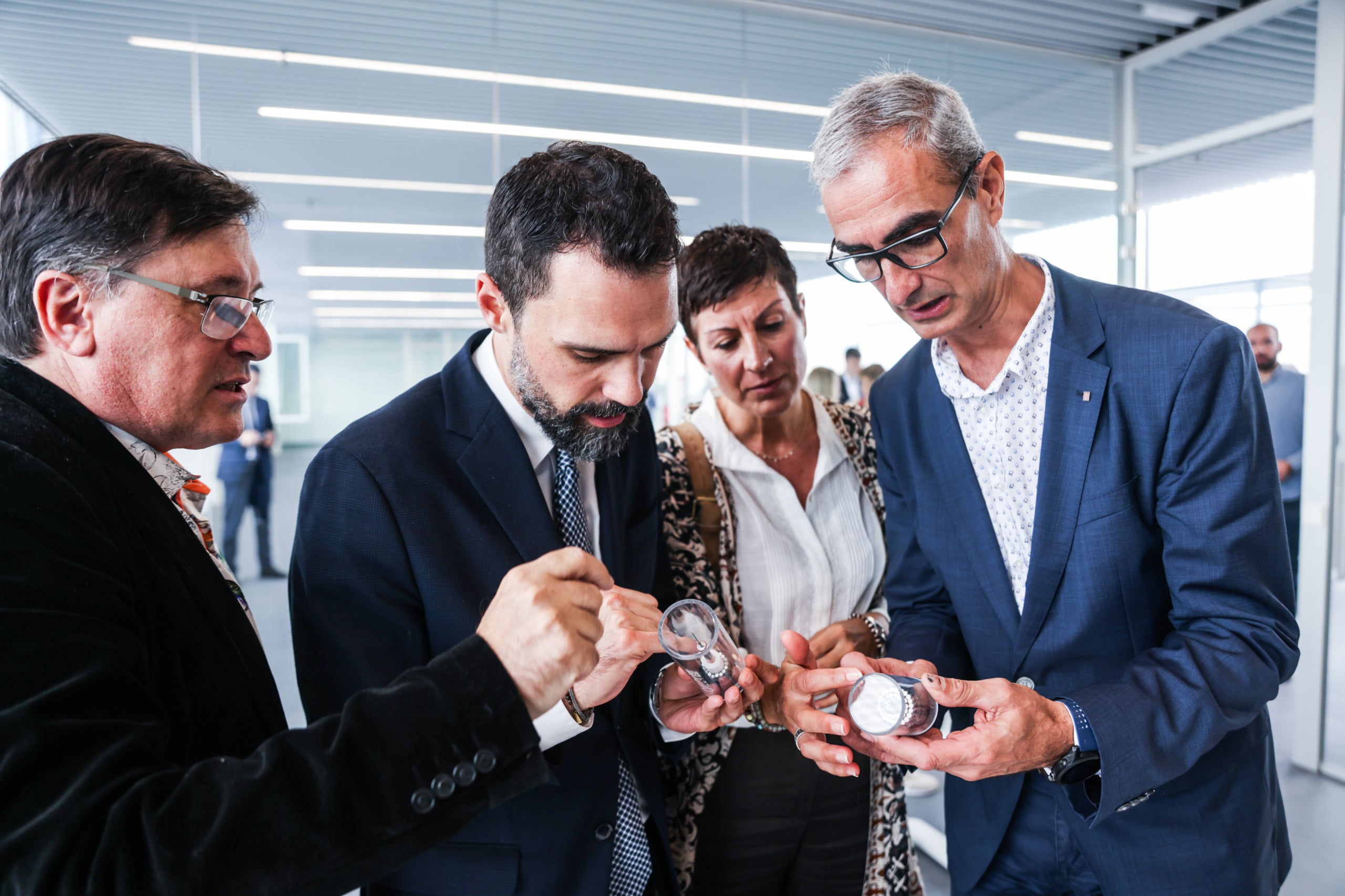 El conseller d Empresa i Treball, Roger Torrent i Ramió, observant una miniatura dels nous cables de fibra òptica submarina del BCLS / Cedida