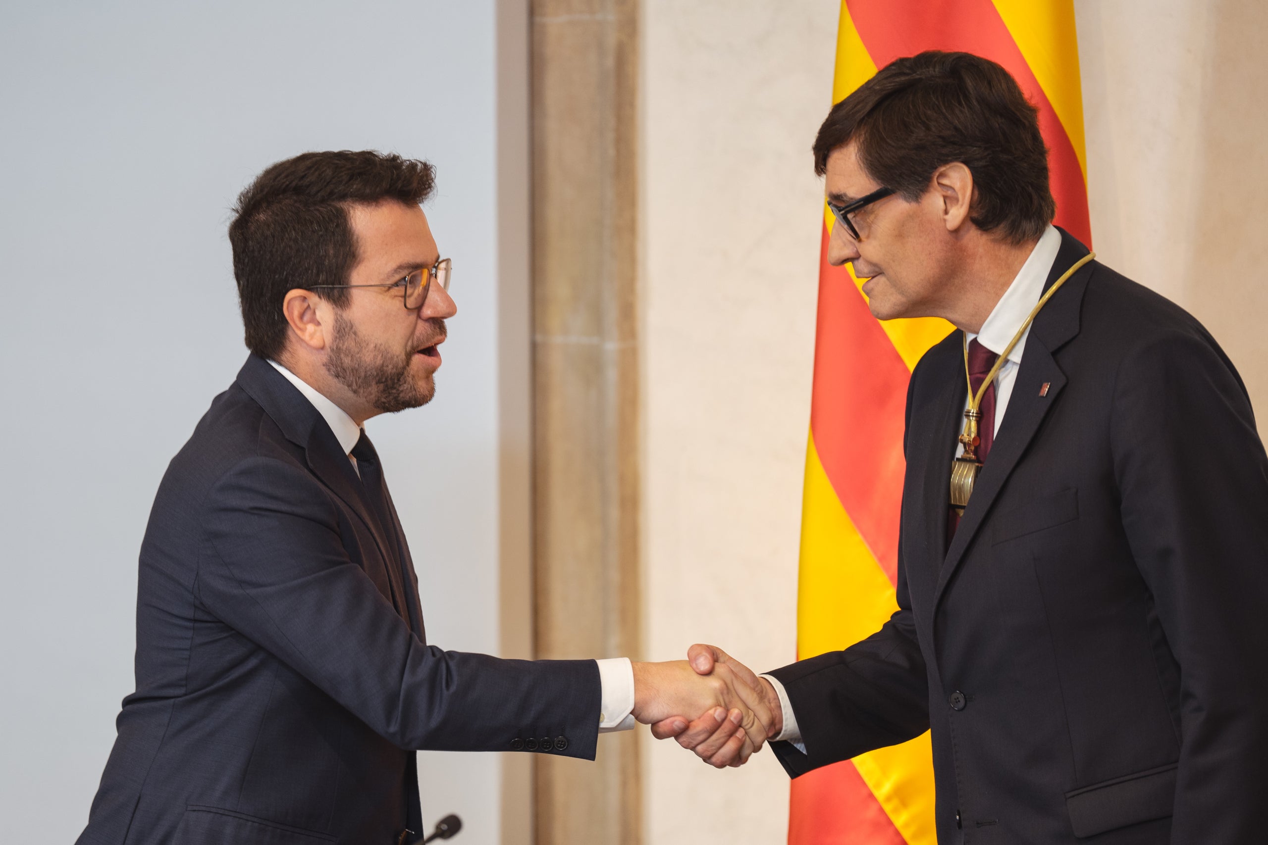 Aragonès i Illa encaixen les mans durant l'acte de presa de possessió del nou president socialista | Marc Font (ACN)