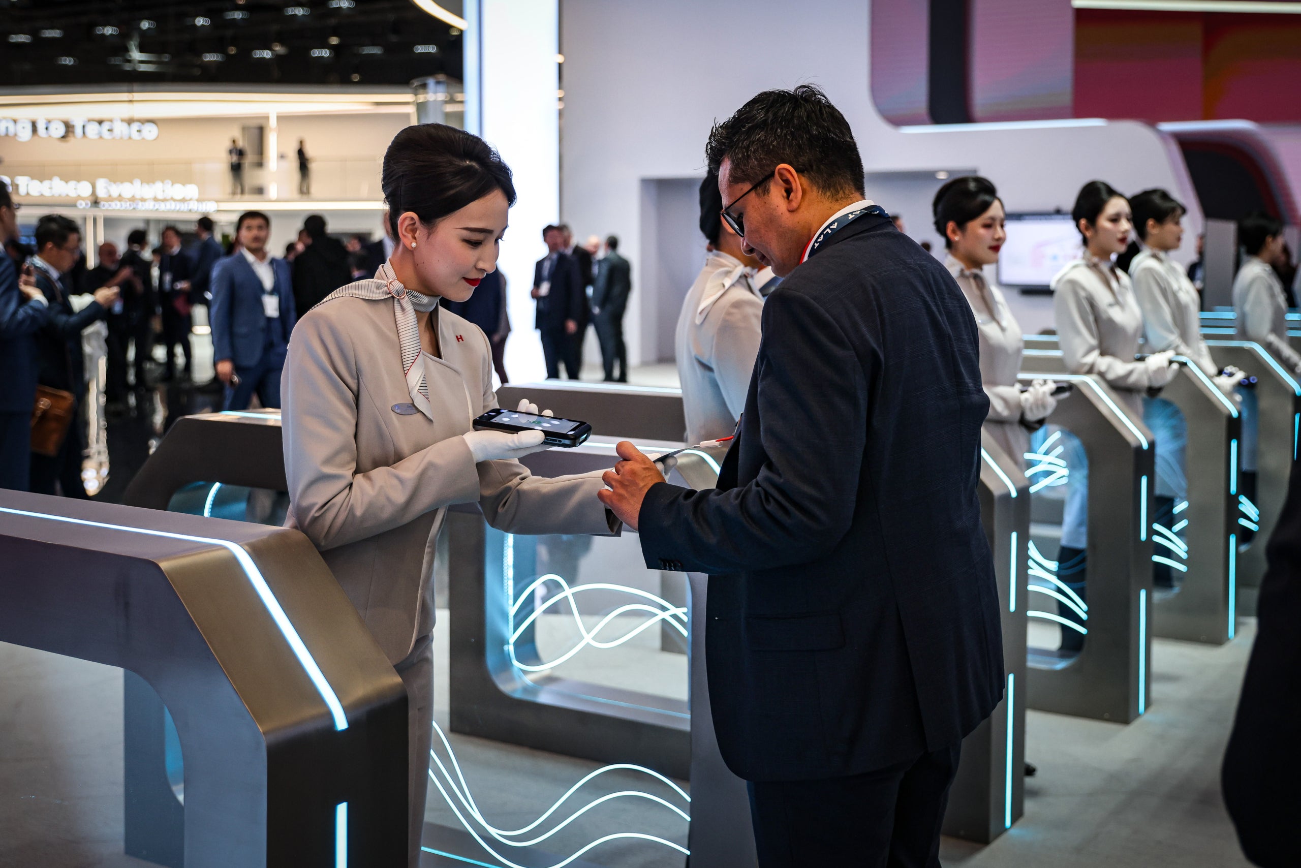 Un asistente al MWC 2025 muestra la acreditación a una de las azafatas de la feria / Jordi Borràs