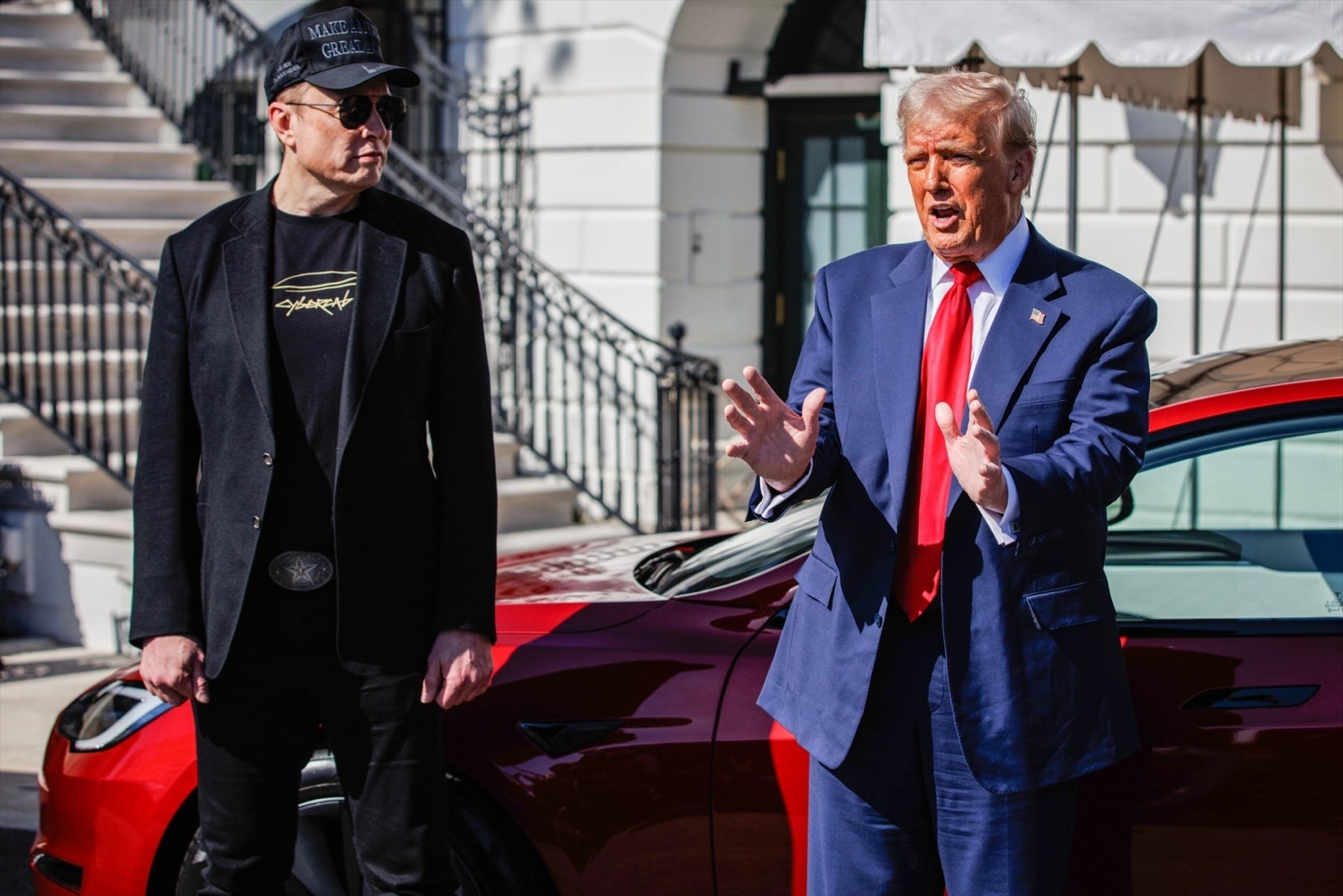 Donald⁢ Trump and Elon ‍Musk wiht a car at the White House