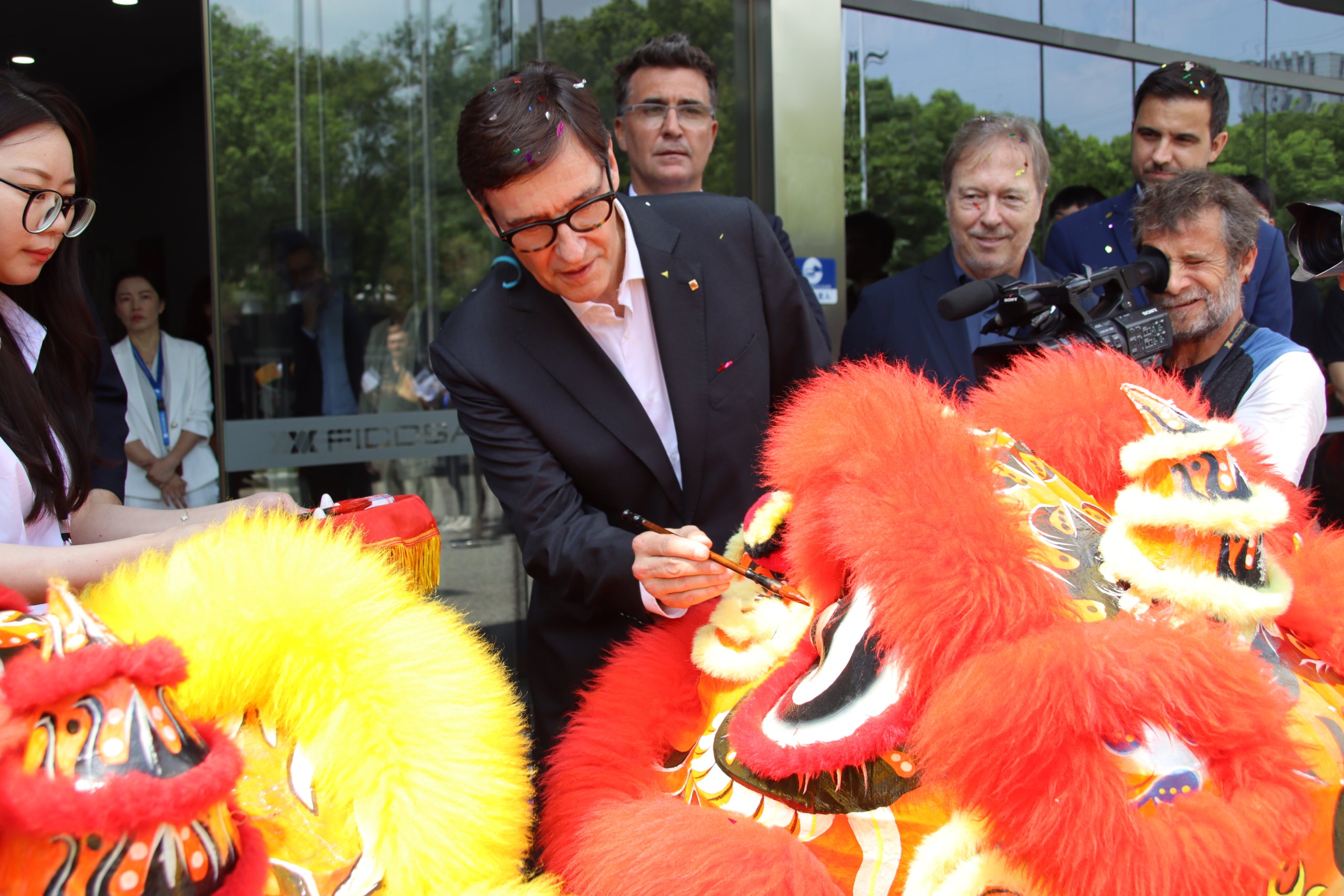 El president de la Generalitat, Salvador Illa, pintant un ull a un lleó xinès a les instal·lacions de Ficosa a Taicang / ACN