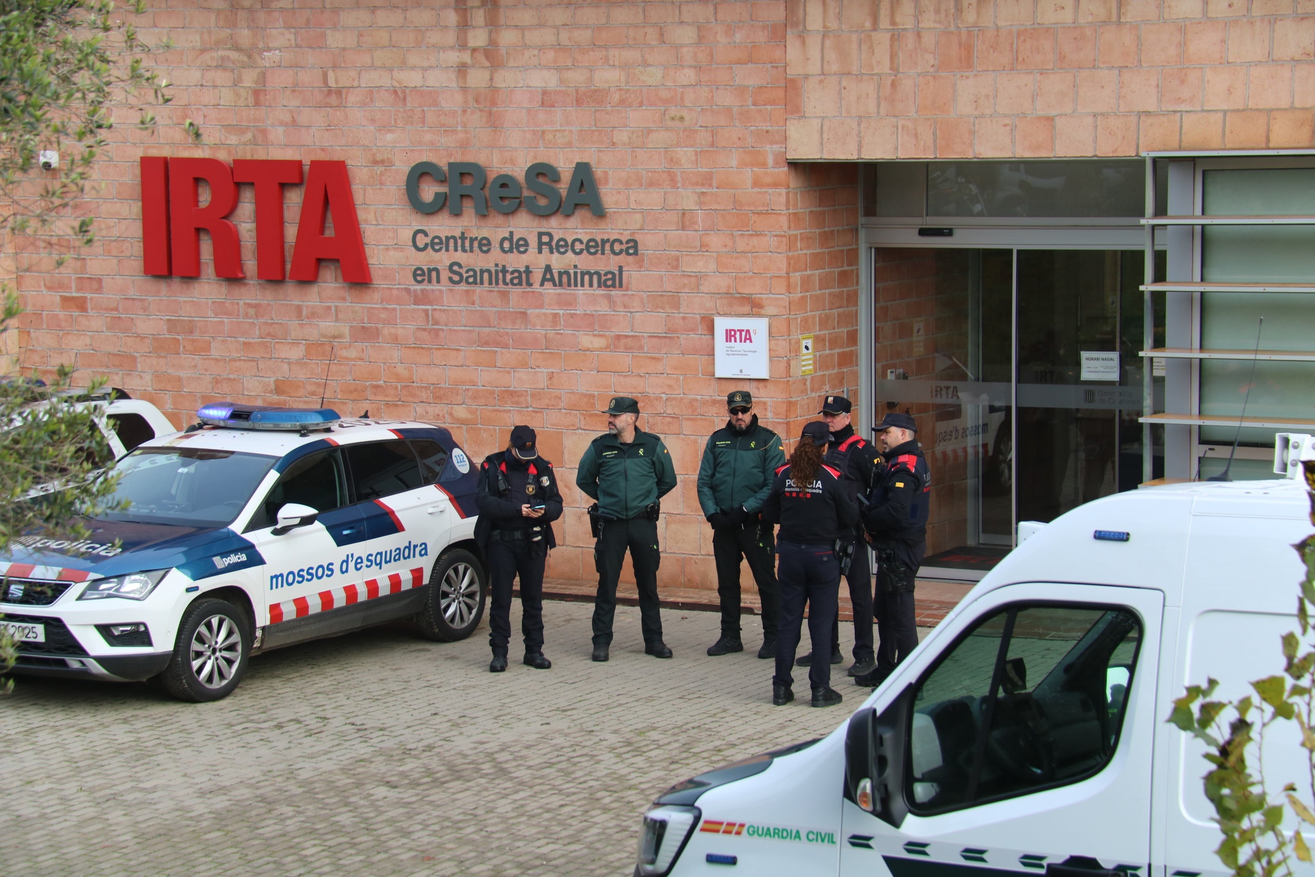 Agents dels Mossos i de la Guàrdia Civil davant de les instal·lacions de l'IRTA-CReSA / ACN