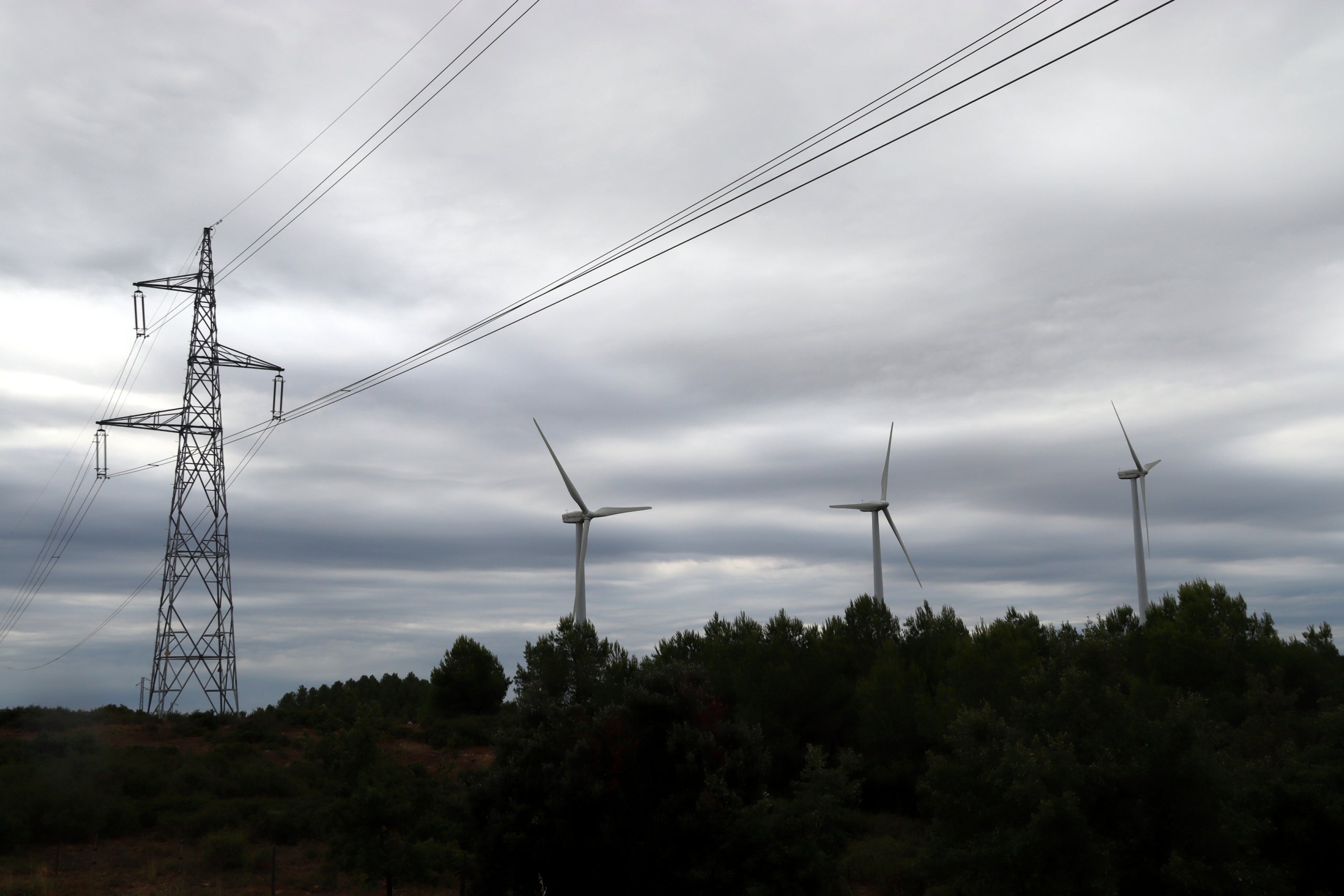 Una torre elèctrica aèria amb molins al costat a Rubió.  Autor: ACN/ Mar Martí 